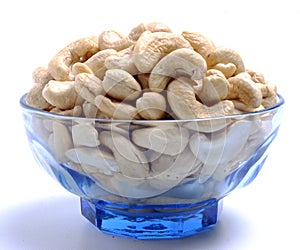 Tasty cashew nuts on blue bowl with white background