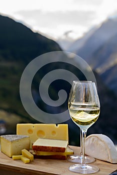 Tasty cheese and wine from Savoy region in France, beaufort, abondance, emmental, tomme and reblochon de savoie cheeses and glass