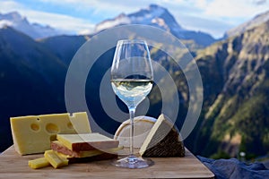 Tasty cheese and wine from Savoy region in France, beaufort, abondance, emmental, tomme and reblochon de savoie cheeses and glass