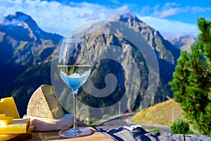 Tasty cheese and wine from Savoy region in France, beaufort, abondance, emmental, tomme and reblochon de savoie cheeses and glass