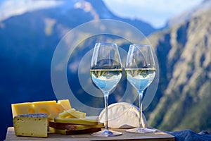 Tasty cheese and wine from Savoy region in France, beaufort, abondance, emmental, tomme and reblochon de savoie cheeses and glass