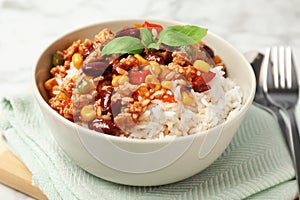 Tasty chili con carne served with rice in bowl