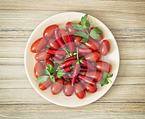 Tasty chili peppers and cherry tomatoes on the plate