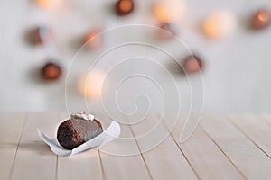 Tasty chocolate cake on a wooden natural background. Top decorated with cream and a piece of jelly. In the background glow round l photo
