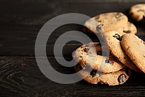 Tasty chocolate chip cookies on wooden table.