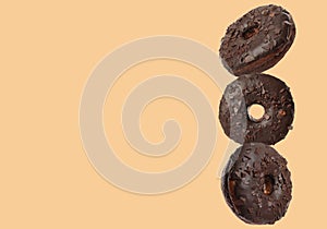 Tasty chocolate donuts on moccasin color background, space for text