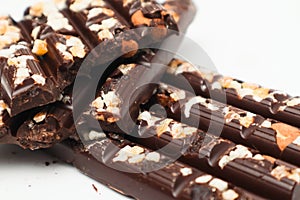 Tasty chocolate with nuts. Chocolate pieces with nuts on white background. Selective focus