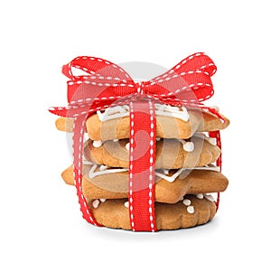 Tasty Christmas cookies tied with ribbon on white background