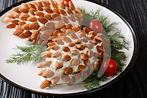 Tasty Christmas food cheese salad with almonds in the form of cones close-up on a plate on the table. horizontal