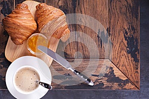 Tasty classical croissant and coffee cappuccino on table