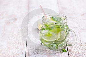 Tasty colorful drink with cold green tea, mint and cucumber in a glass jar