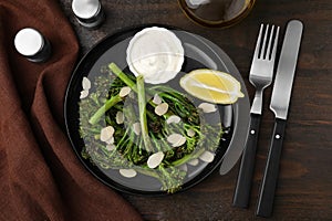 Tasty cooked broccolini served on wooden table, flat lay