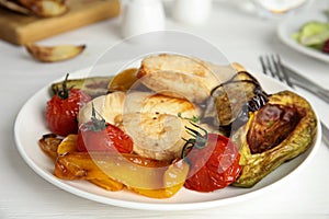 Tasty cooked chicken fillet and vegetables served on white wooden table, closeup. Healthy meals from air fryer