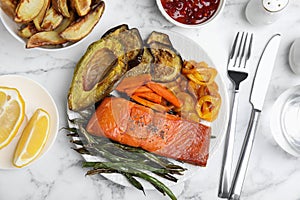 Tasty cooked salmon and vegetables served on white marble table, flat lay. Healthy meals from air fryer