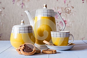 Tasty cookies with chocolate, cup of espresso and a coffee set with a sugar bowl and a spoon