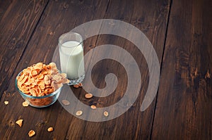 Tasty corn flakes in bowl with glass of milk