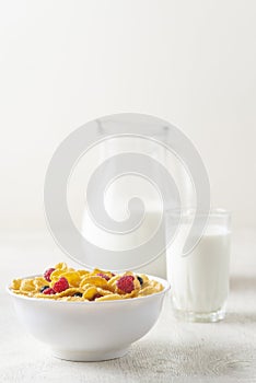 Tasty corn flakes with raspberries and blueberries on white background.Breakfast.