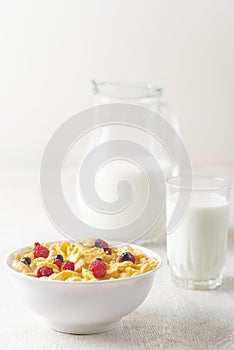 Tasty corn flakes with raspberries and blueberries on white background.Breakfast.