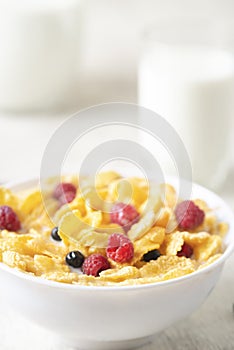 Tasty corn flakes with raspberries and blueberries on white background.Breakfast.