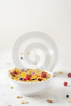 Tasty corn flakes with raspberries and blueberries on white background.Breakfast.