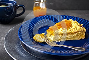 Tasty cottage cheese pie with jam on blue plate.