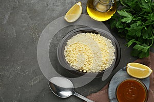 Tasty couscous and ingredients on grey table, flat lay. Space for text