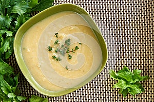 Tasty cream of celeriac soup in a green bowl photo