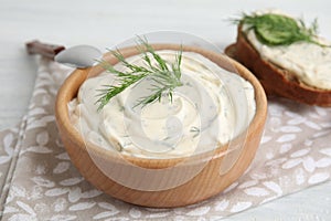 Tasty creamy dill sauce in wooden bowl on table, closeup