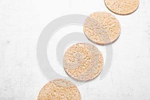 Tasty crispbreads on white textured table, above view. Space for text