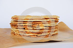 Tasty crispy baked round puff pastry layers of homemade traditional Russian napoleon cake on parchment