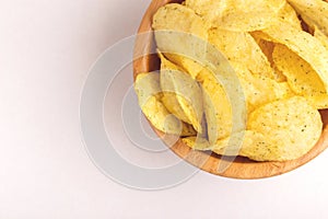 Tasty crispy potato chips in wooden bowl