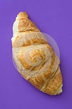 Croissant on violet background. Top view photo