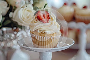 Tasty cupcake with creamy topping and slice of strawberry on the top, sweet buffet