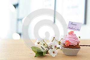 Tasty cupcake and flowers for Mother`s Day