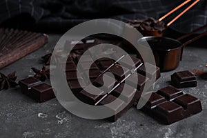 Tasty dark chocolate bars on grey table