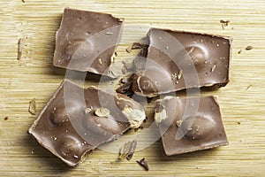 Tasty dark chocolate with hazelnuts on a wooden board. A delicious dessert favorite by children and adults