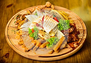 Tasty delicious snacks. Snack for beer. Restaurant food. Wooden board with lot french fries fish sticks burrito and meat
