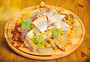 Tasty delicious snacks. Snack for beer. Restaurant food. Wooden board with lot french fries fish sticks burrito and meat