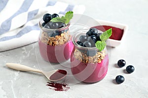 Tasty dessert with acai smoothie, granola and berries on marble table