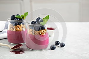 Tasty dessert with acai smoothie, granola and berries on table. Space for text