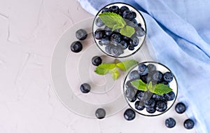 Tasty dessert with fresh blueberries, yogurt and chia seeds on the grey background. Healthy breakfast in the morning. Top view.