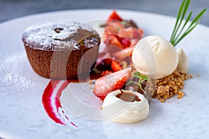 Tasty dessert, hot chocolate cake and vanilla ice cream with fresh strawberry