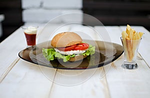 Tasty dinner with fast food. Burger with eggs, tomato, salad and