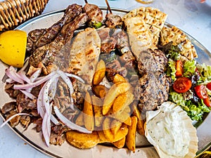 Tasty dish with greek tzatziki sauce, a mixture of various types of grilled meat