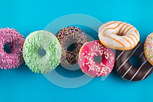 Tasty doughnuts on blue background. Close up