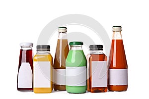 Tasty drinks in bottles with blank labels on white background