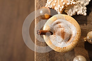 Tasty eggnog with cinnamon, cookies and Christmas baubles on wooden table, flat lay. Space for text