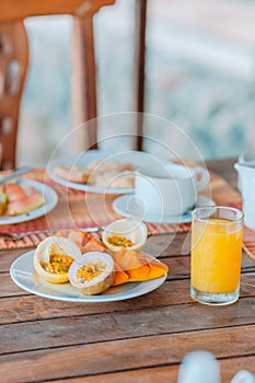 Tasty exotic fruits - ripe passion fruit, mango on breakfast at outdoor restaraunt