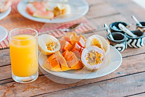 Tasty exotic fruits - ripe passion fruit, mango on breakfast at outdoor restaraunt