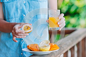 Tasty exotic fruits - ripe passion fruit, mango on breakfast at outdoor restaraunt